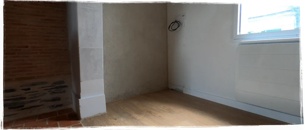 Espace vide à côté d’une cheminée dans une longère à Beaufort-en-Vallée, avant la création d’un meuble sur mesure pour le bois de chauffage